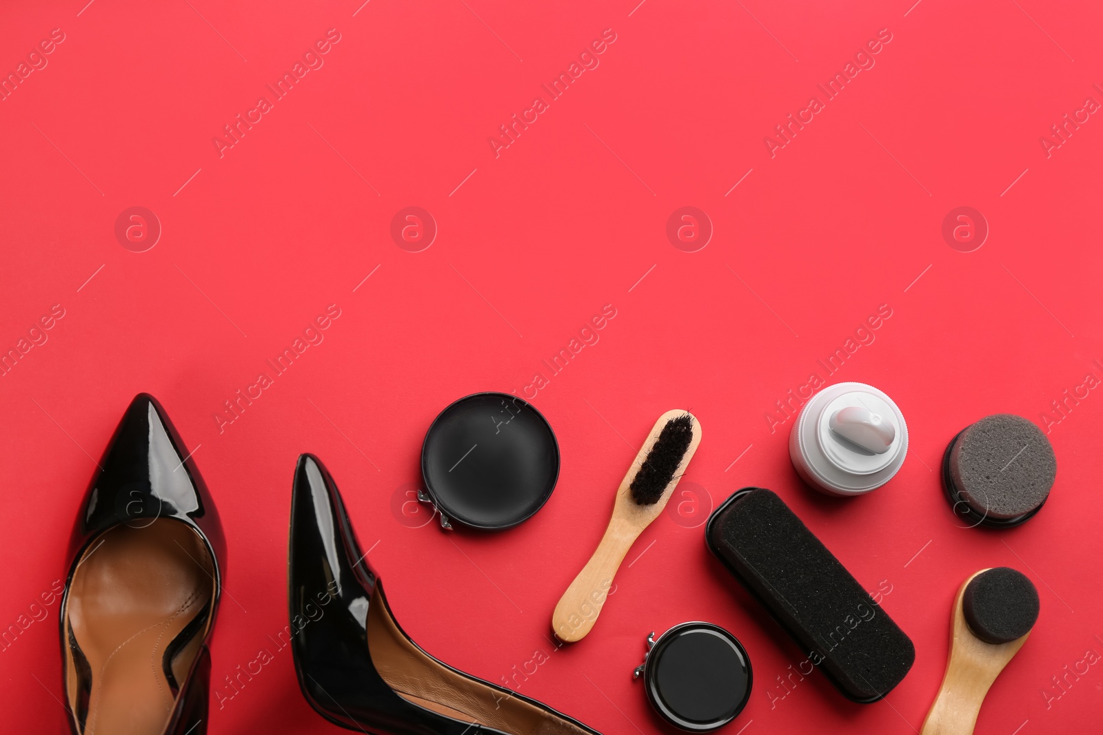 Photo of Flat lay composition with shoe care accessories and footwear on red background. Space for text