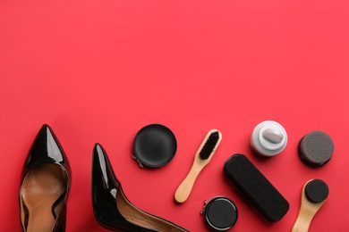 Flat lay composition with shoe care accessories and footwear on red background. Space for text