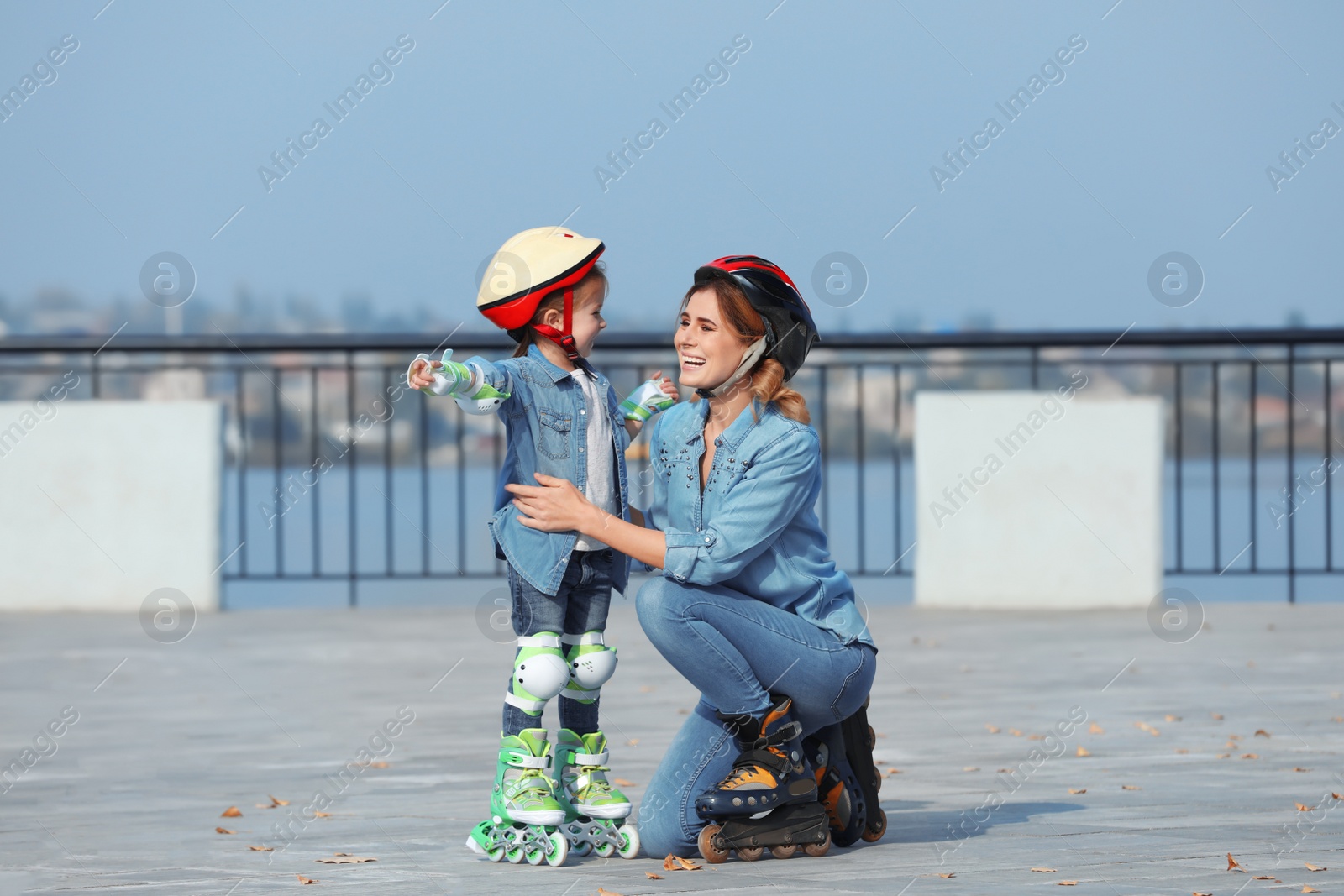 Photo of Mother and her daughter wearing roller skates on city street