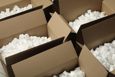 Open cardboard boxes with pieces of polystyrene foam on floor. Packaging goods
