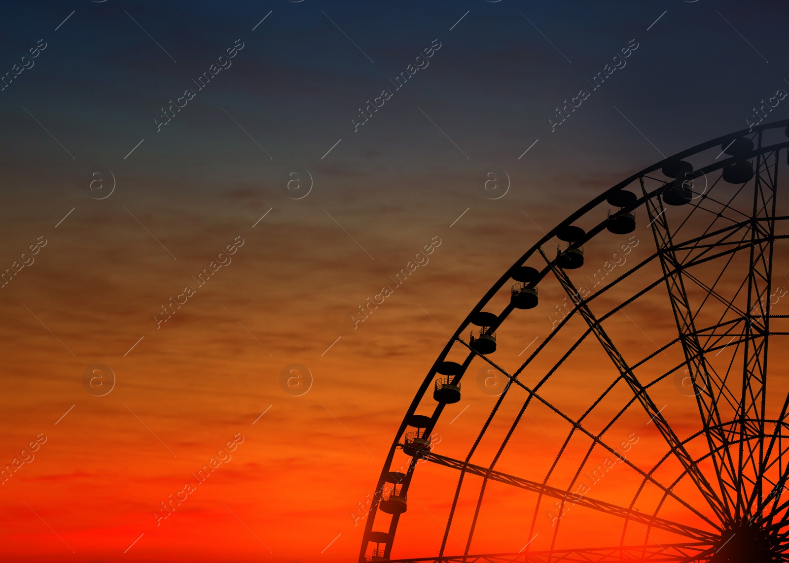 Image of Beautiful large Ferris wheel outdoors at sunset, space for text