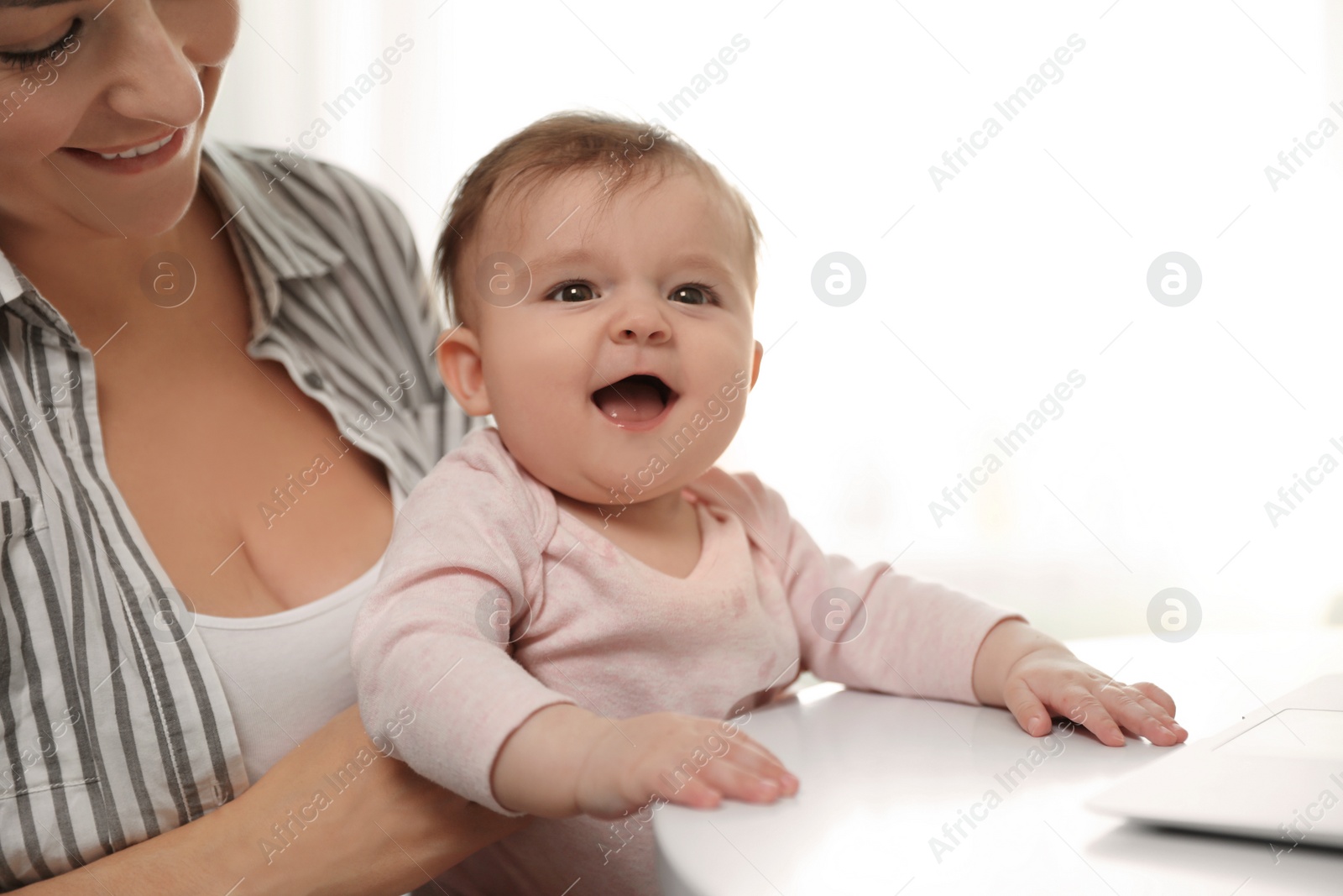 Photo of Young woman with her cute baby at home