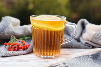 Cup of hot drink and scarf on window sill indoors. Cozy autumn atmosphere