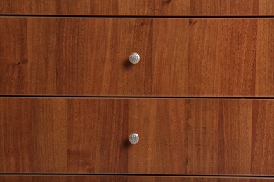 Photo of Wooden wardrobe drawers as background, closeup view