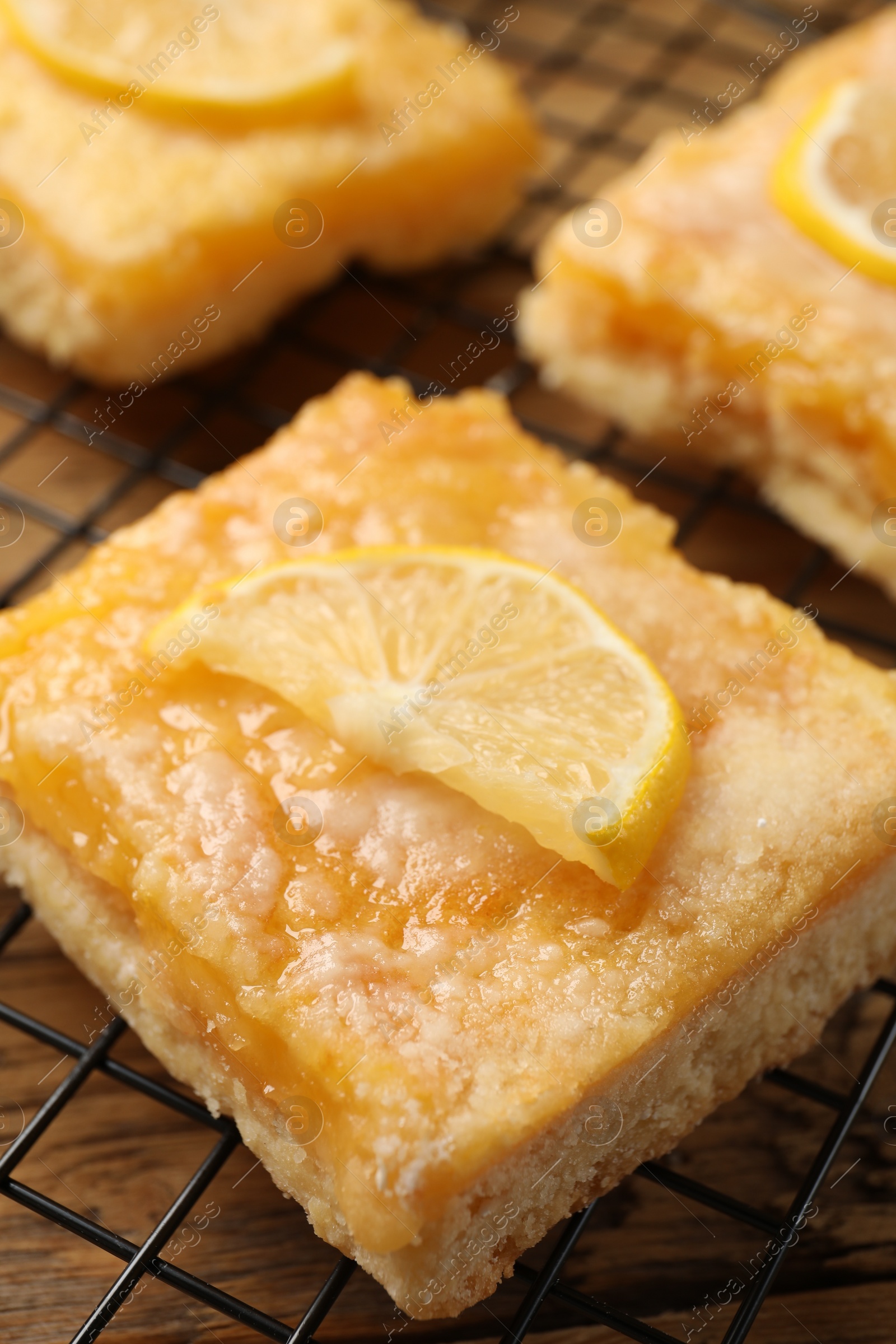 Photo of Tasty lemon bars on cooling rack, closeup