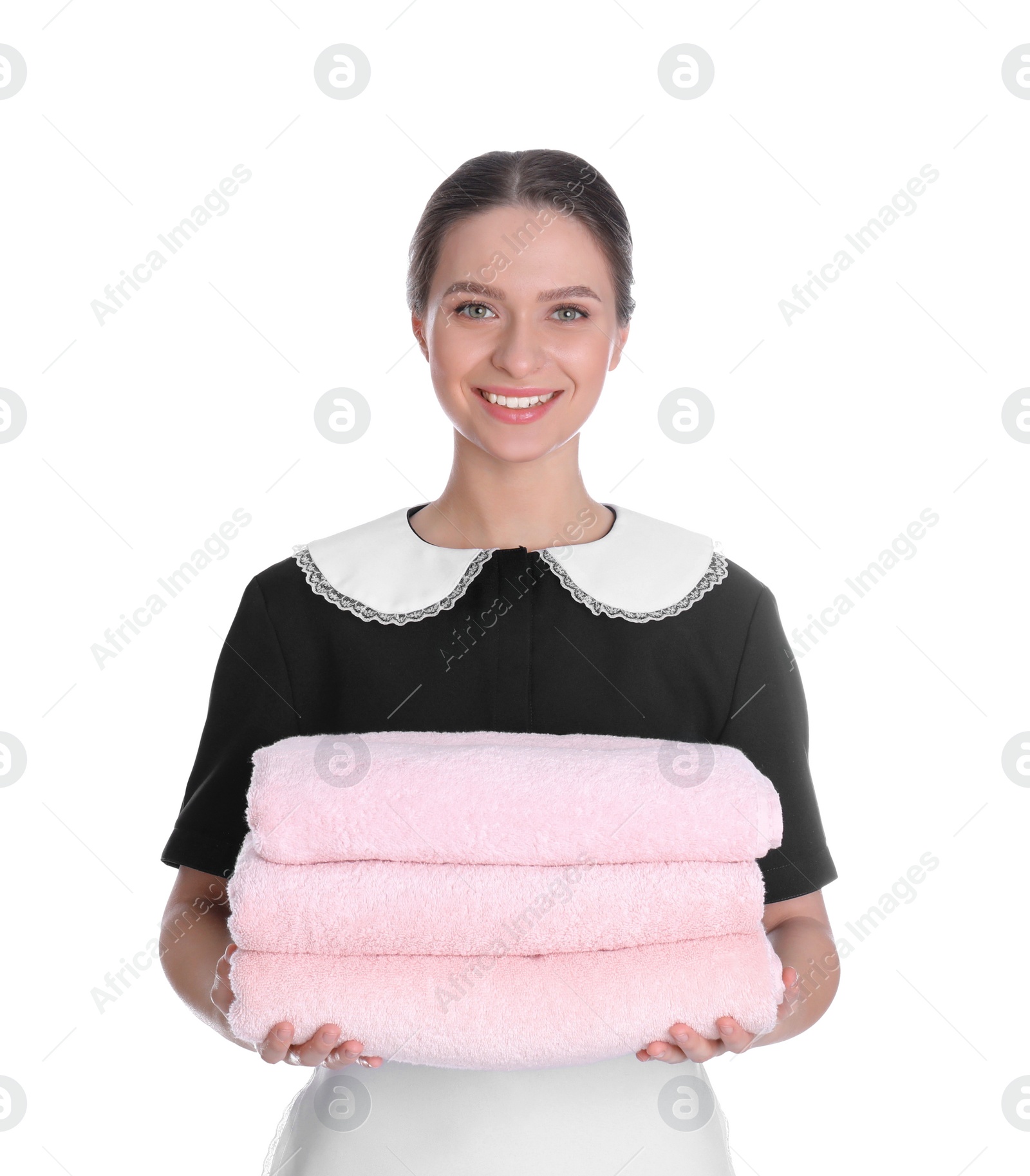 Photo of Young chambermaid holding stack of fresh towels on white background