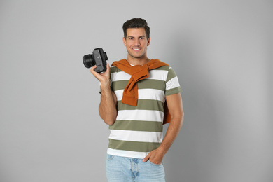 Photo of Professional photographer working on light grey background in studio