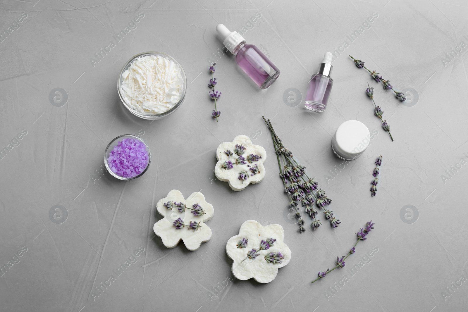 Photo of Flat lay composition of handmade soap bars with lavender flowers and ingredients on grey stone background