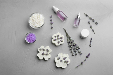 Photo of Flat lay composition of handmade soap bars with lavender flowers and ingredients on grey stone background