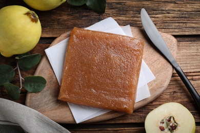 Photo of Delicious quince paste and fresh fruits on wooden table, flat lay