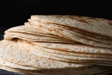 Photo of Many tasty homemade tortillas on table, closeup