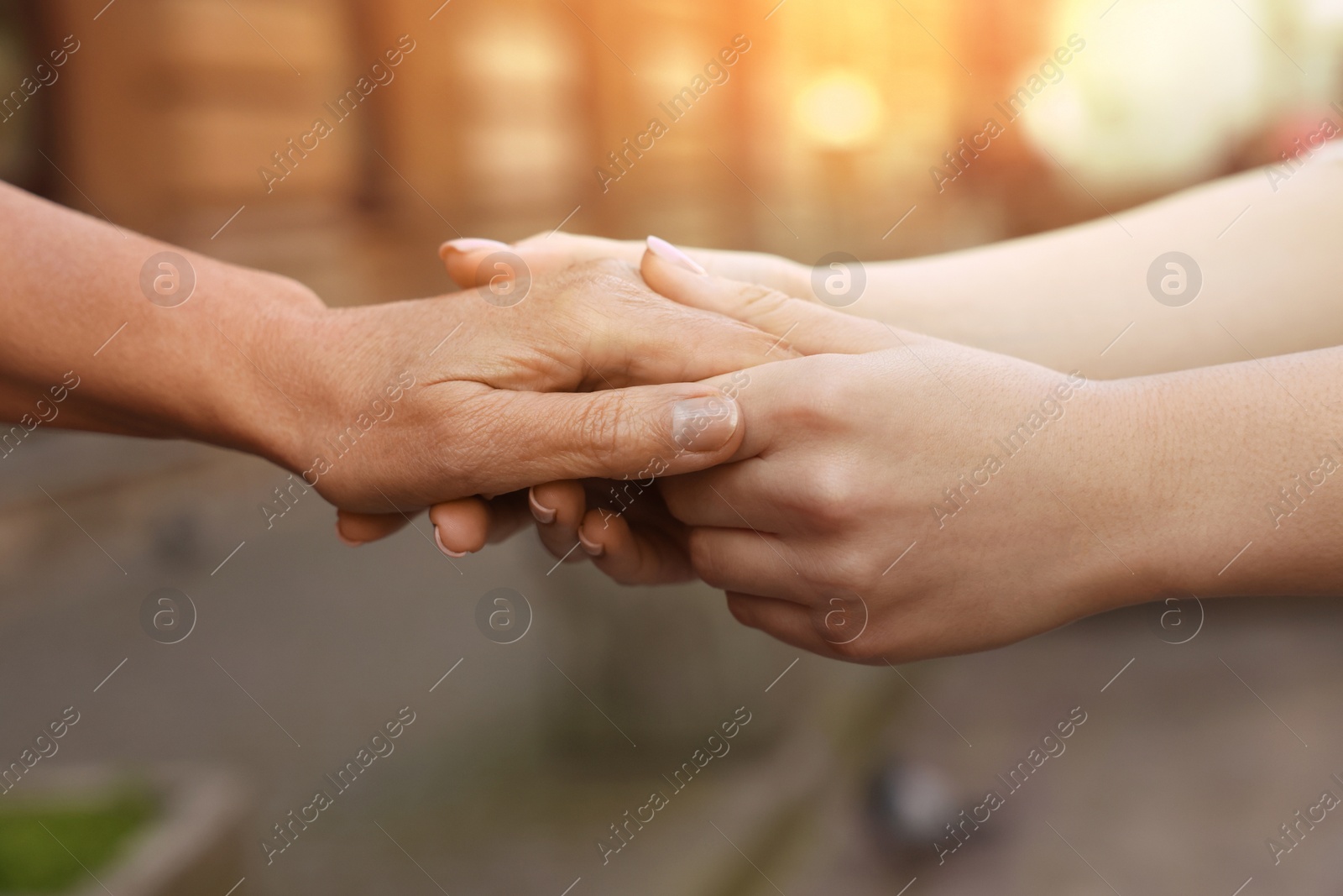 Photo of Trust and support. Women joining hands outdoors, closeup