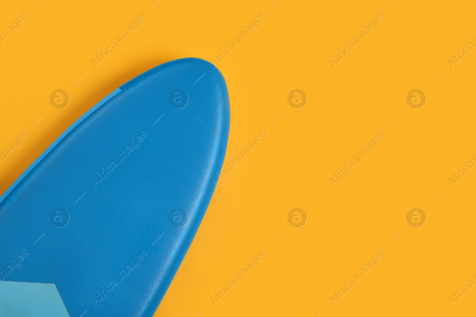 Photo of One SUP board on yellow background, top view with space for text. Water sport