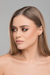 Photo of Beautiful woman with makeup on grey background