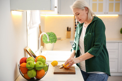 Photo of Woman with tablet cooking at counter in kitchen