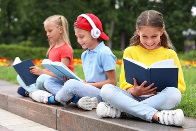 Group of kids reading books on street