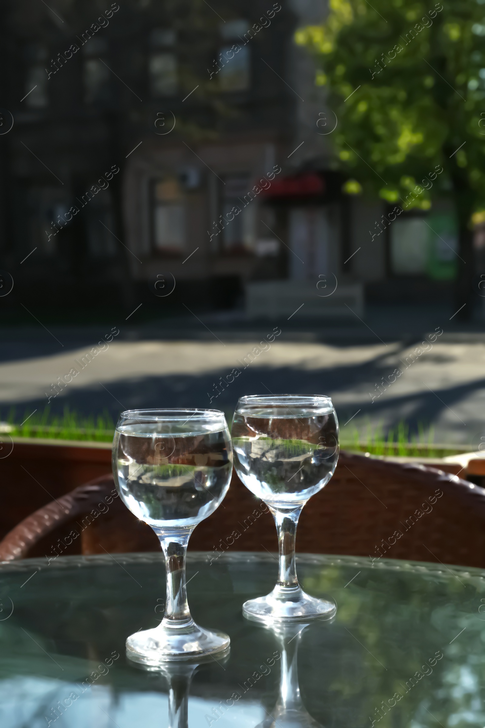 Photo of Two glasses of water at table in cafe, after coffee refreshing drink