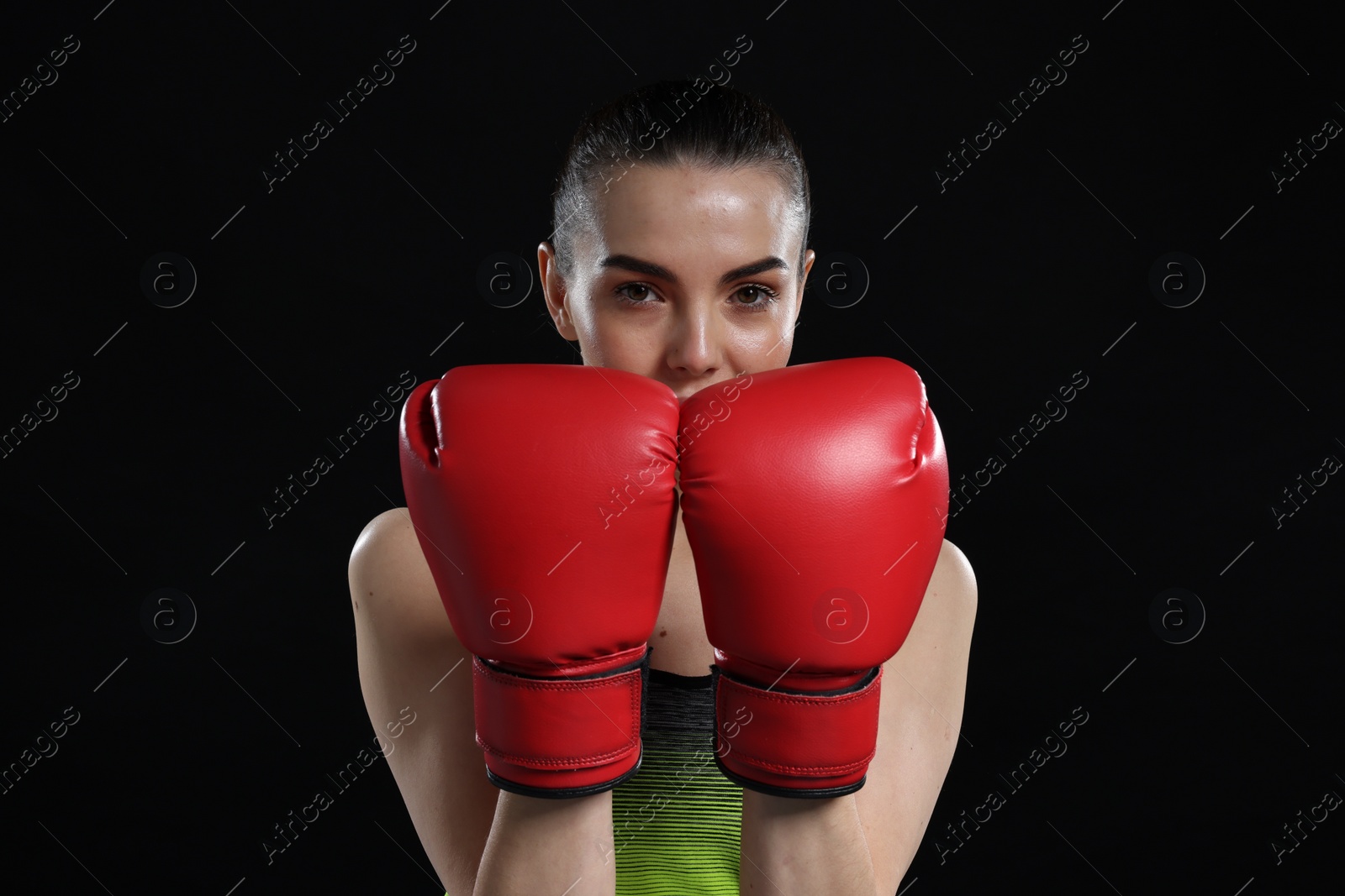 Photo of Portrait of beautiful woman in boxing gloves on black background