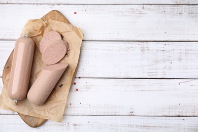 Photo of Board with delicious liver sausage on white wooden table, top view. Space for text