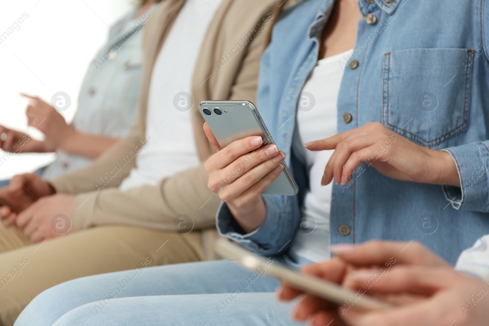 Photo of Young woman using modern smartphone indoors, closeup