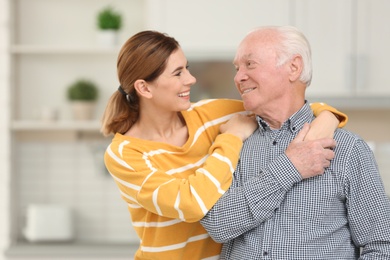 Elderly man with female caregiver in kitchen