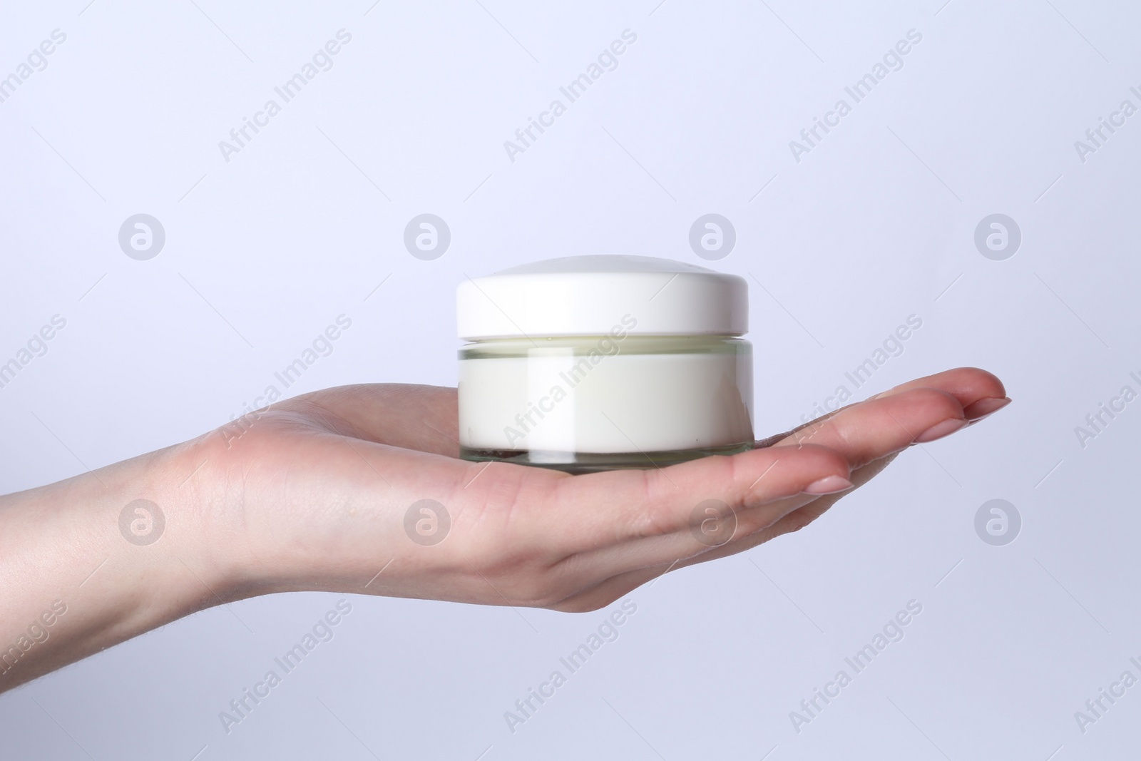 Photo of Woman with jar of cream on white background, closeup