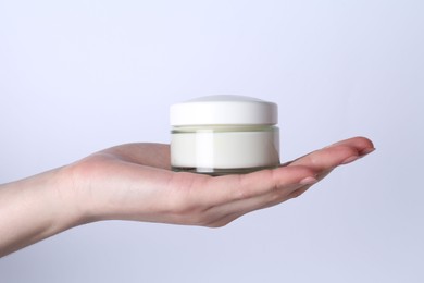 Woman with jar of cream on white background, closeup