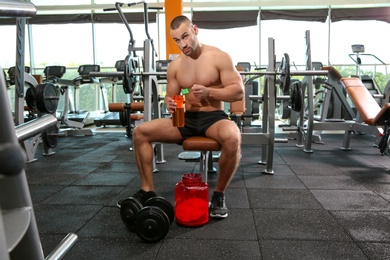 Photo of Portrait of athletic man preparing protein shake in gym
