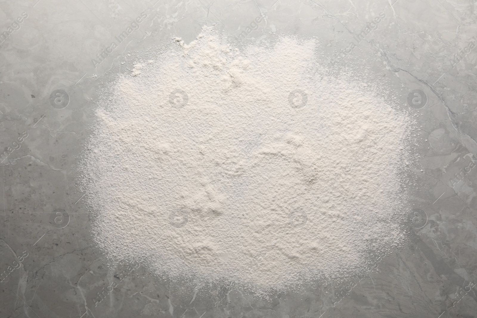 Photo of Pile of flour on grey marble table, top view