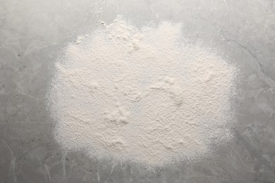 Pile of flour on grey marble table, top view