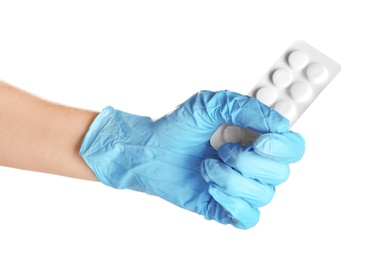 Photo of Doctor in medical glove holding pills on white background