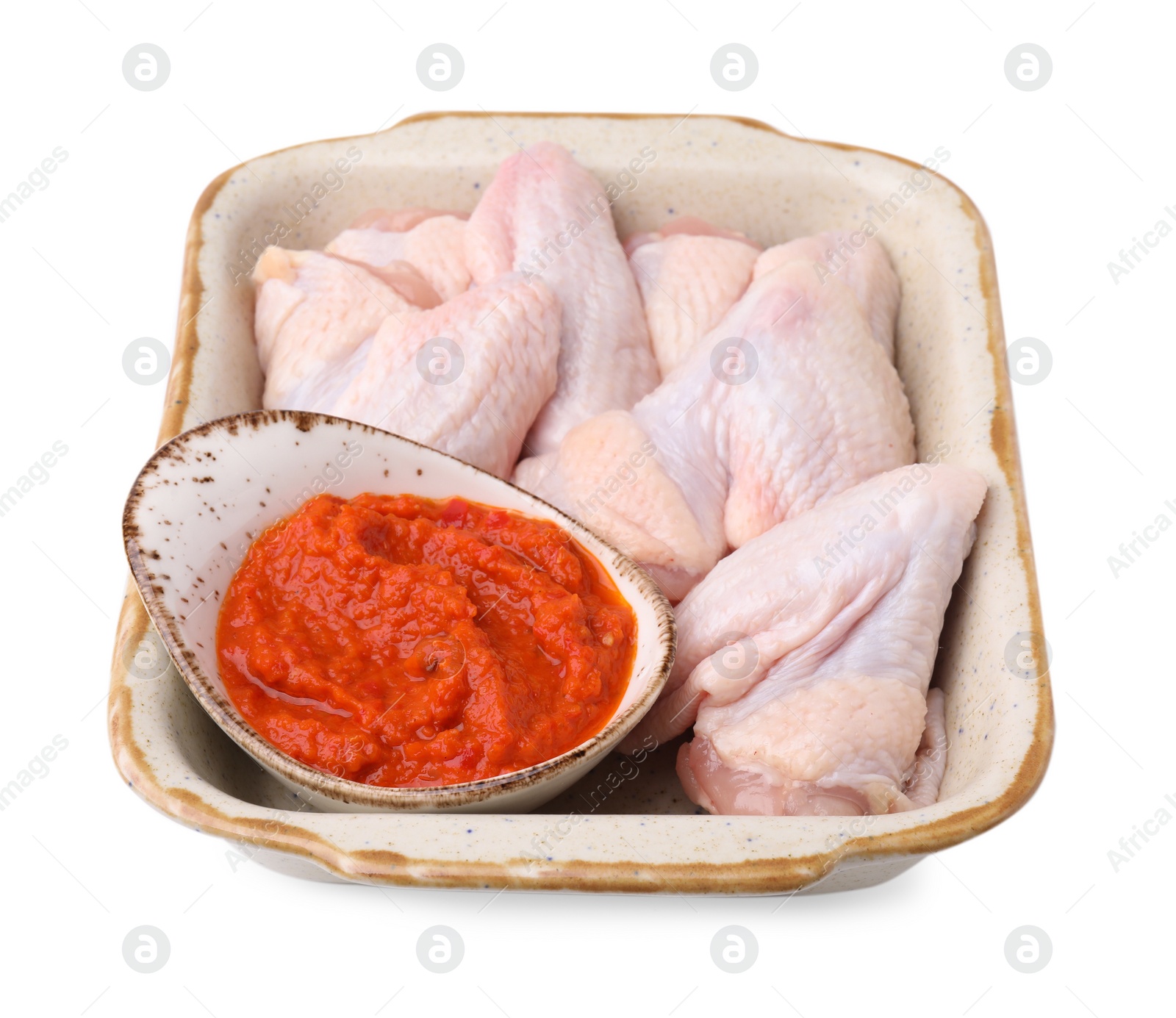 Photo of Fresh marinade and raw chicken in baking dish isolated on white