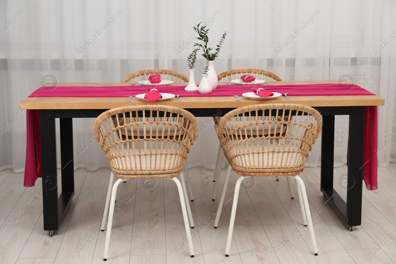 Photo of Beautiful table setting and vases with green branches in dining room