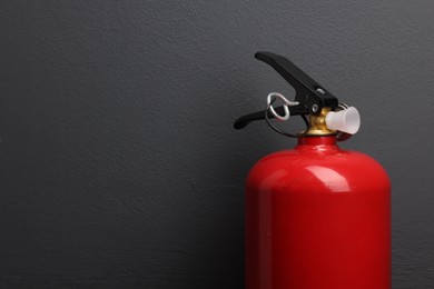 Photo of One fire extinguisher near grey wall, space for text