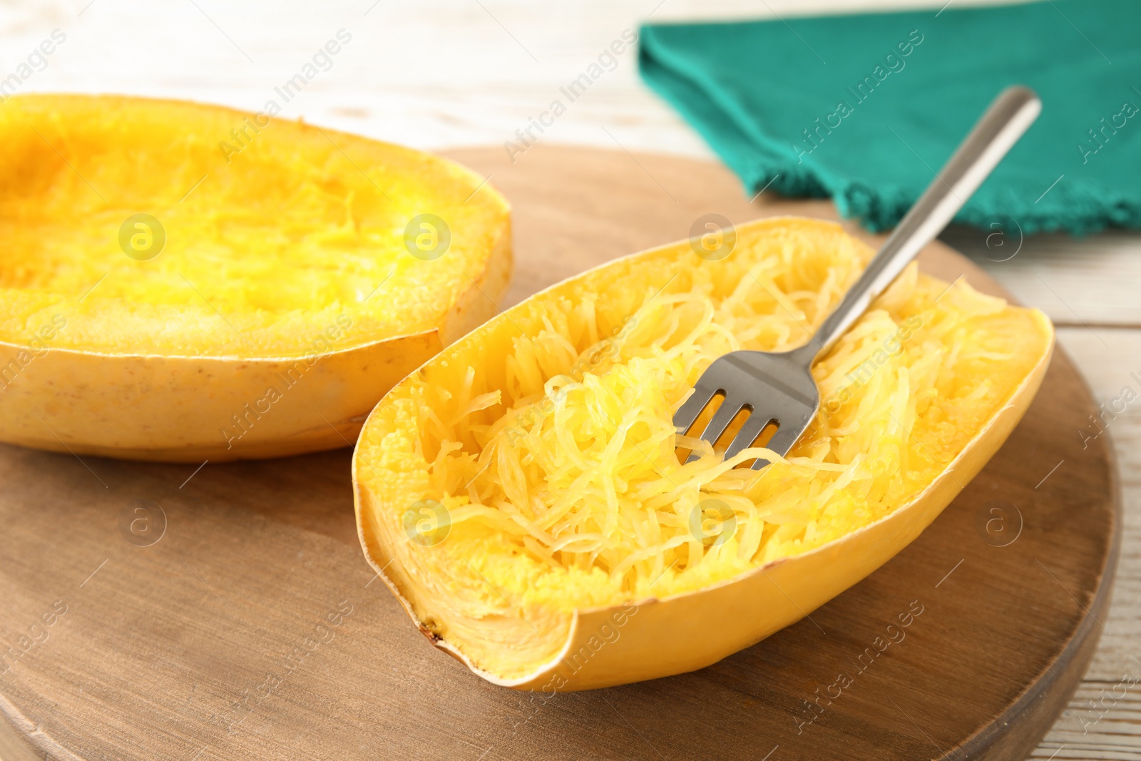 Photo of Cooked spaghetti squash and fork on wooden board