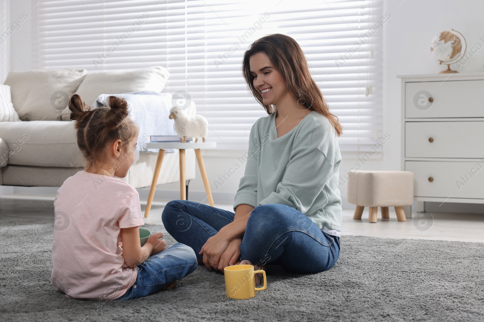 Photo of Young mother and her daughter spending time together at home