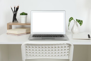 Cozy workspace with laptop and stationery on wooden desk at home