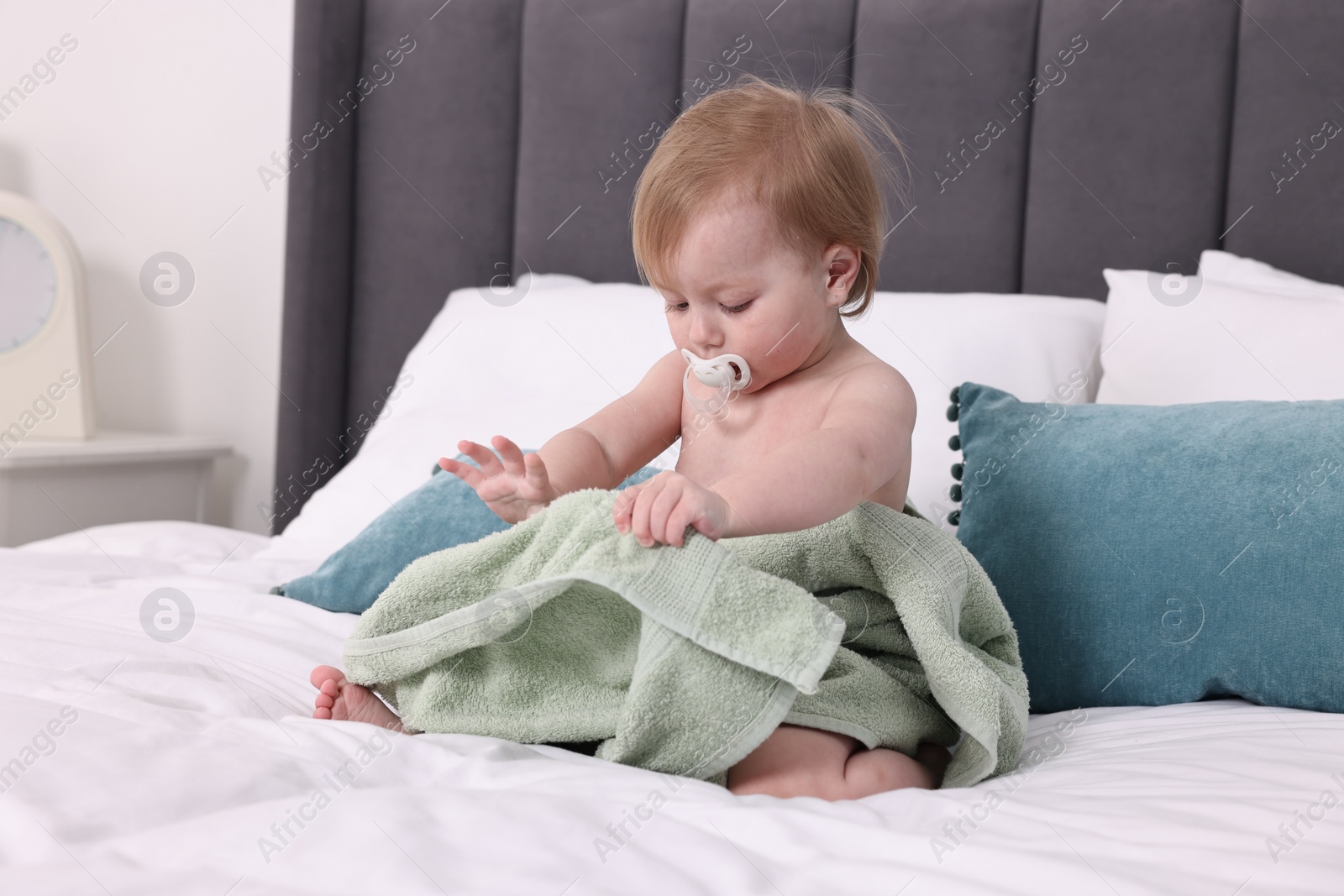 Photo of Cute little baby with towel after bathing on bed