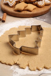 Photo of Making Christmas cookies. Raw dough and cutter on table