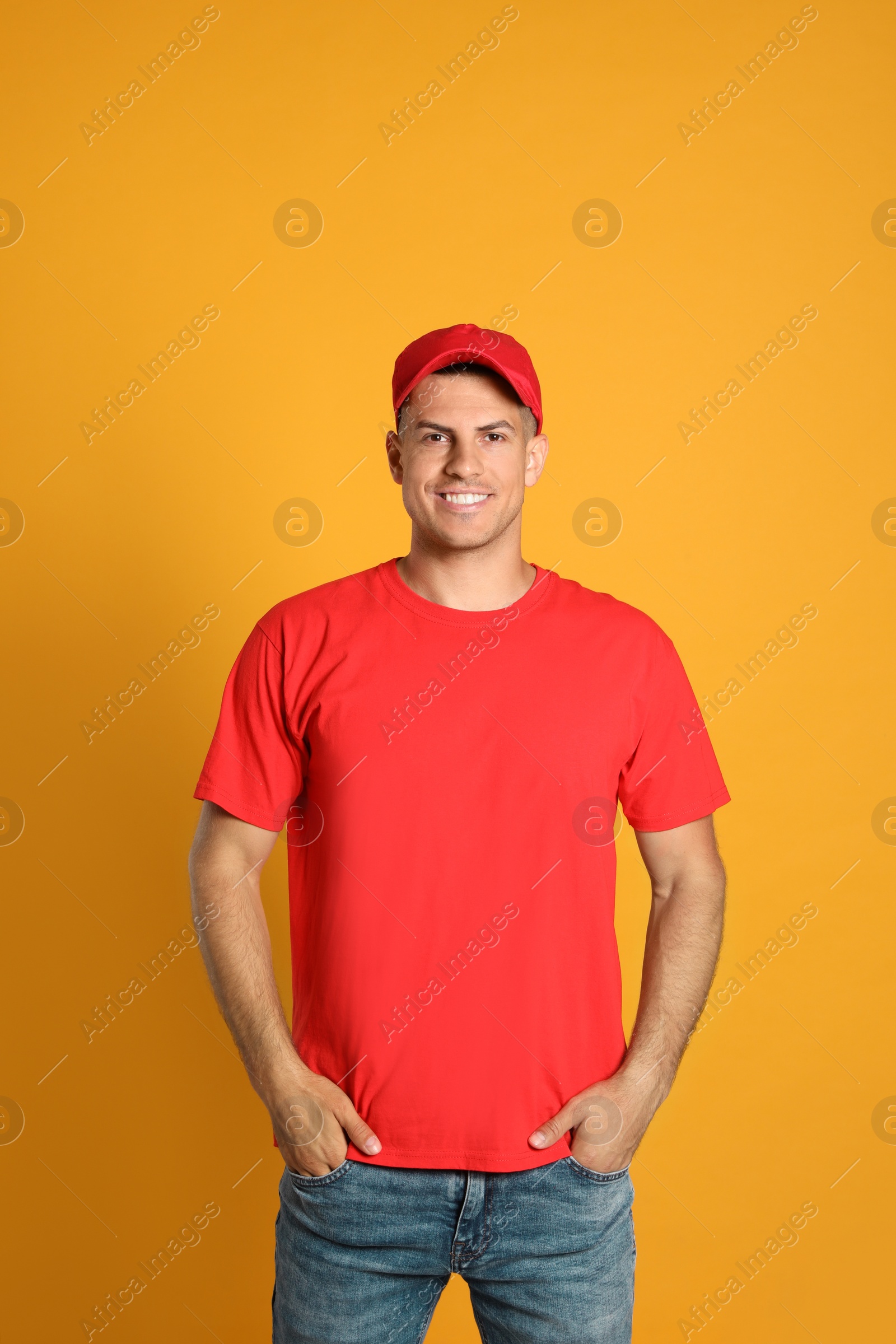 Photo of Happy man in red cap and tshirt on yellow background. Mockup for design