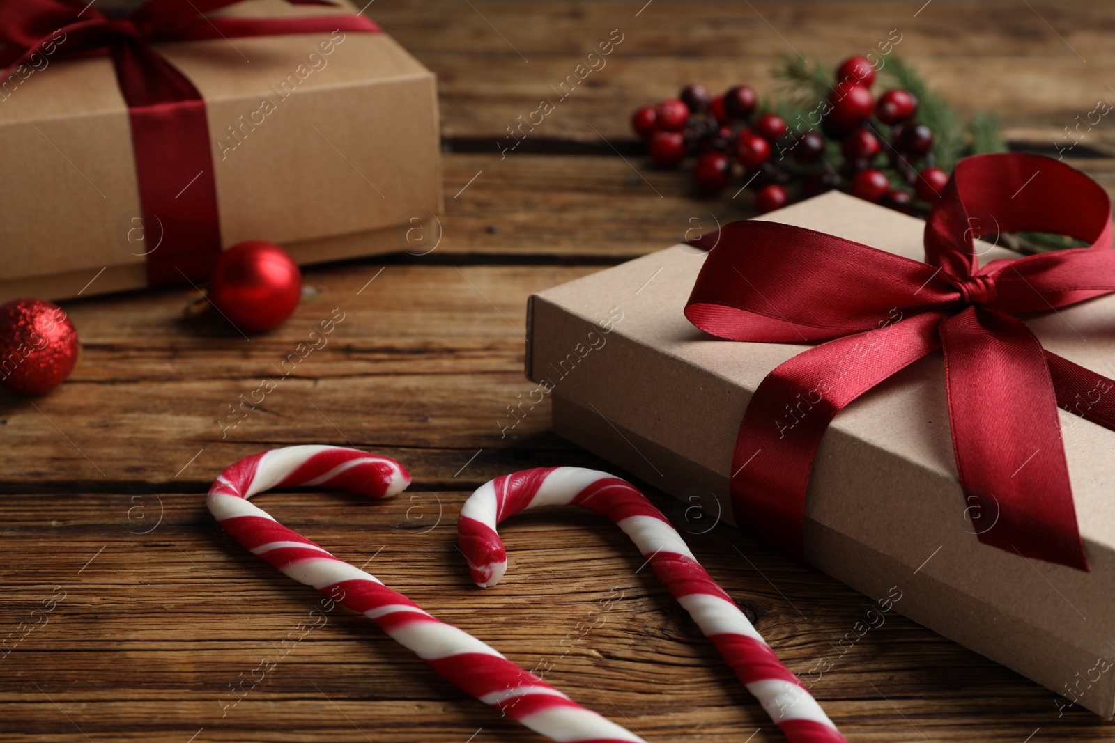 Photo of Gift boxes, candy canes and Christmas decor on wooden table