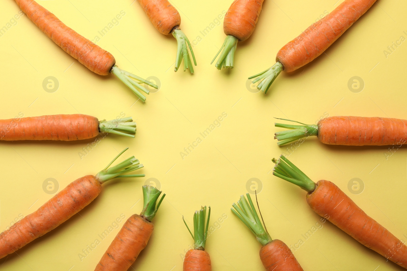 Photo of Flat lay composition with fresh carrots on color background. Space for text