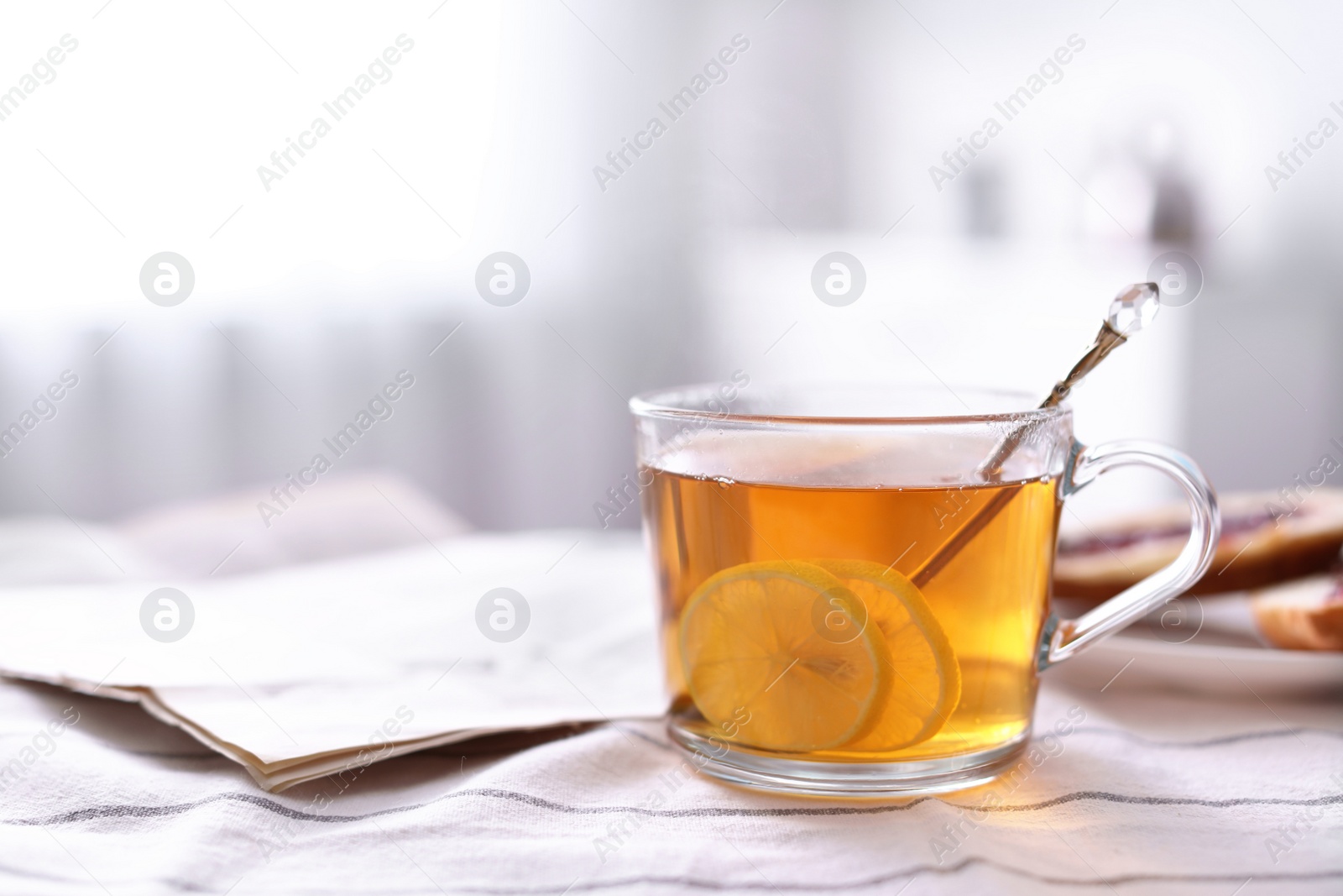 Photo of Morning tea and newspaper on fabric indoors. Space for text