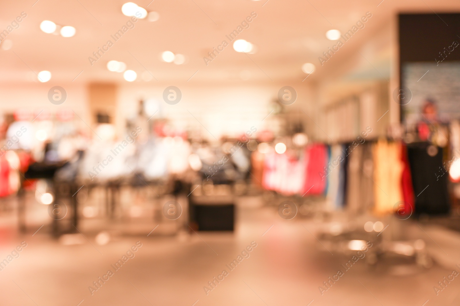 Photo of Blurred view of modern clothes shop interior. Bokeh effect