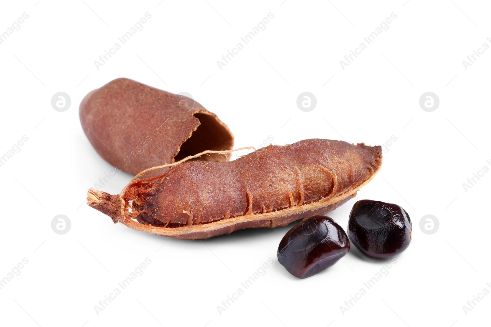 Photo of Delicious ripe tamarinds and seeds on white background. Exotic fruit