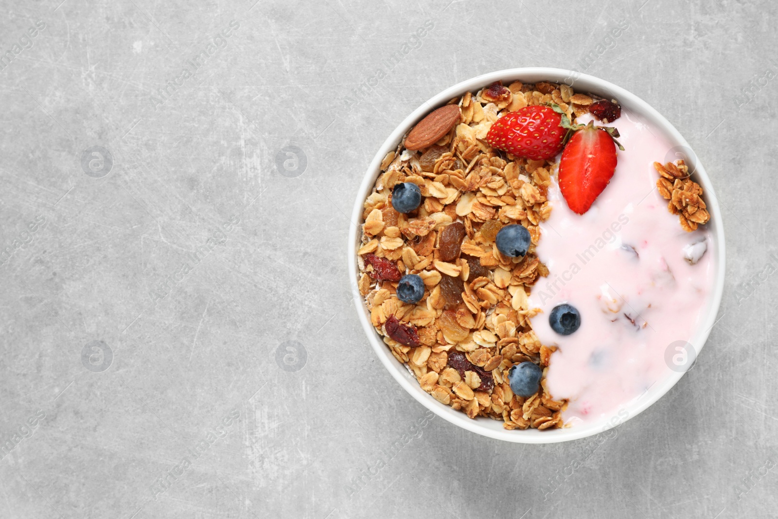 Photo of Tasty homemade granola served on grey table, top view with space for text. Healthy breakfast