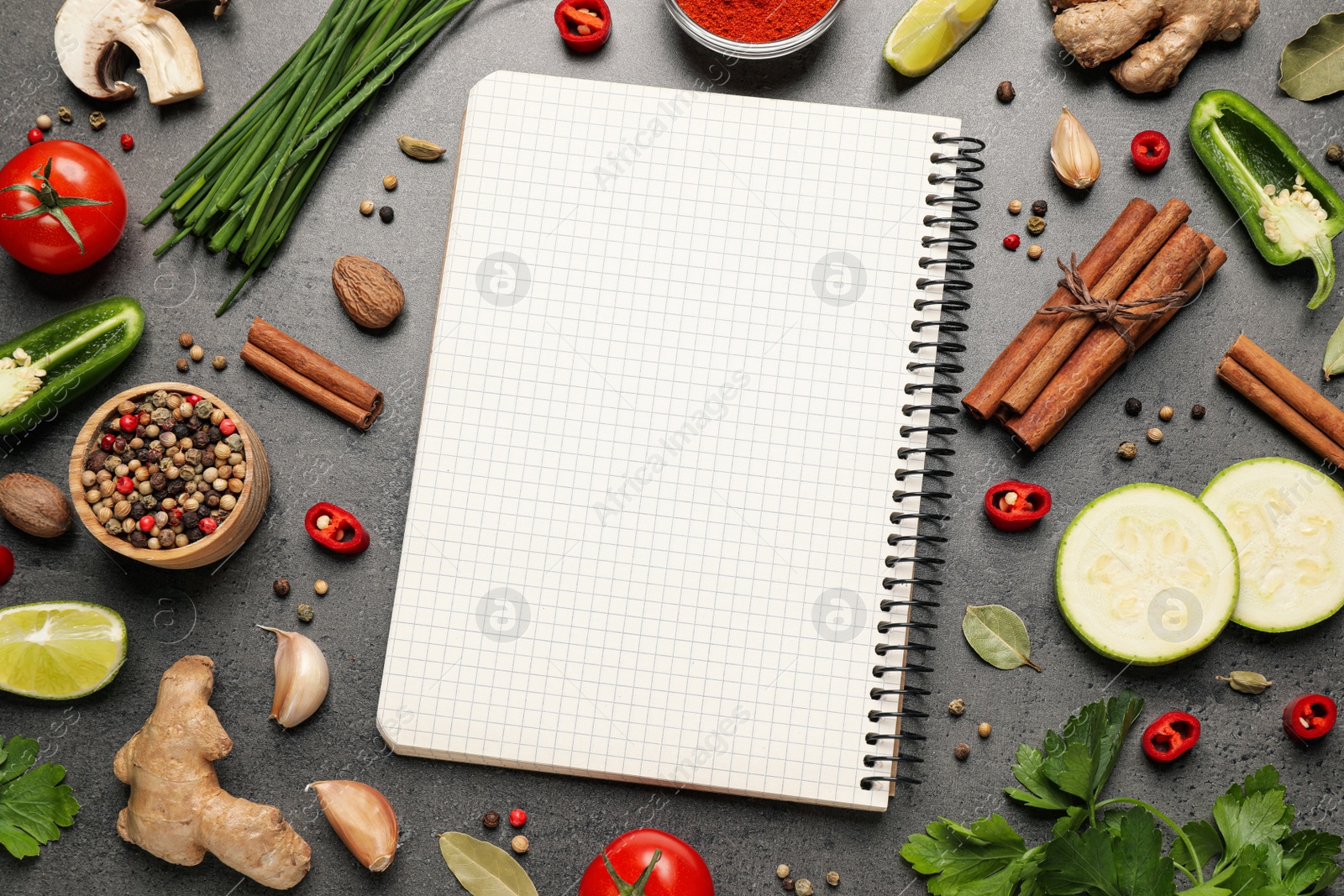 Photo of Blank recipe book and different ingredients on grey table, flat lay. Space for text