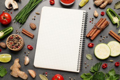Photo of Blank recipe book and different ingredients on grey table, flat lay. Space for text
