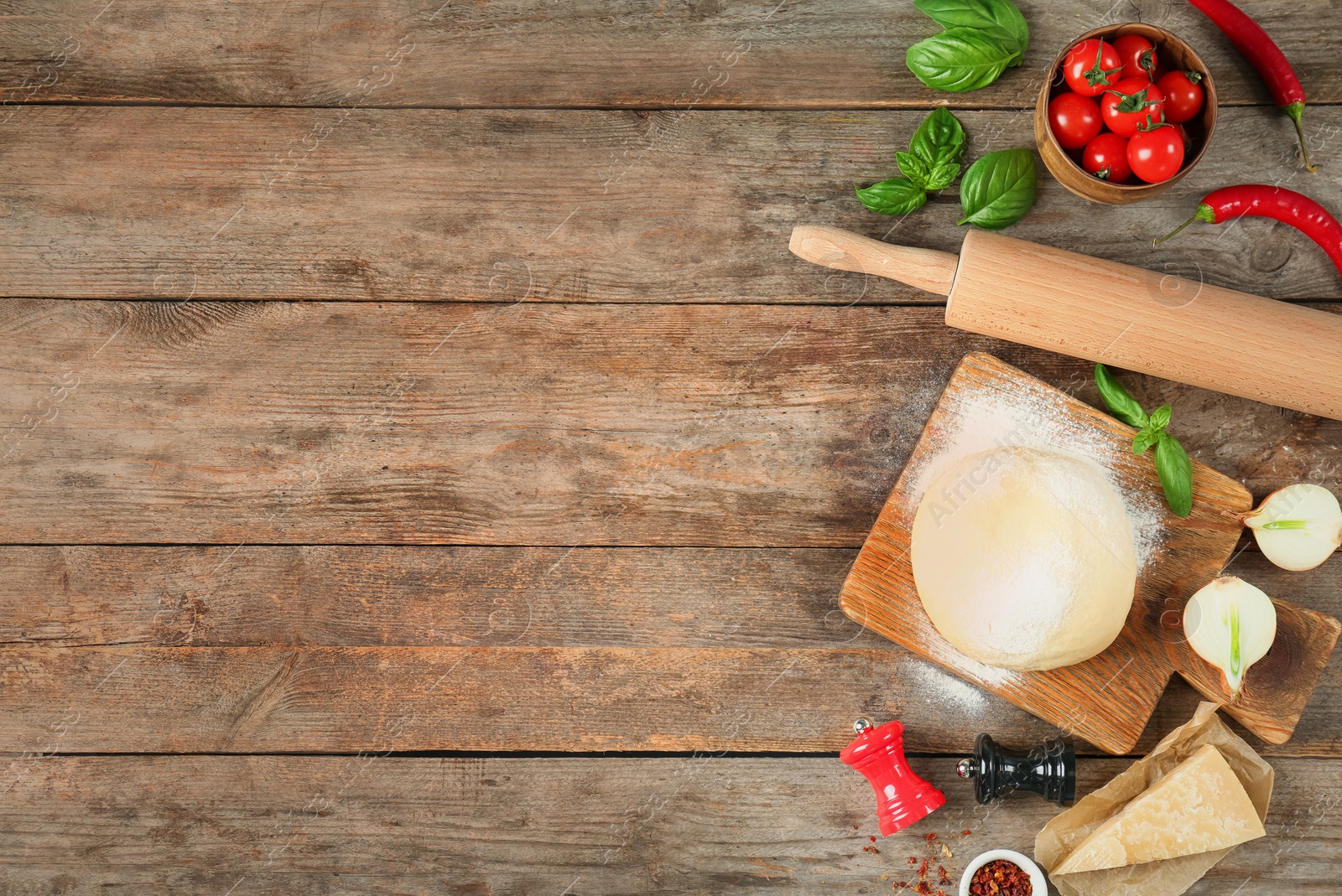 Photo of Dough and ingredients for pizza on wooden background, top view