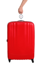 Man weighing stylish suitcase on white background